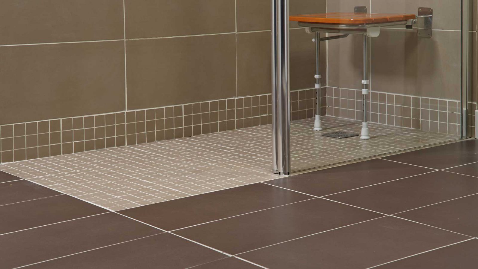 Stepless wetroom decorated with brown and beige tiles