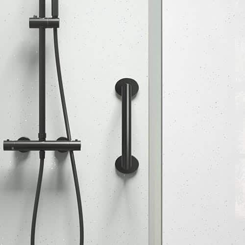 A modern shower with a black showerhead, hose, and control panel on a white speckled wall. A black grab bar is mounted vertically next to the shower fixtures.