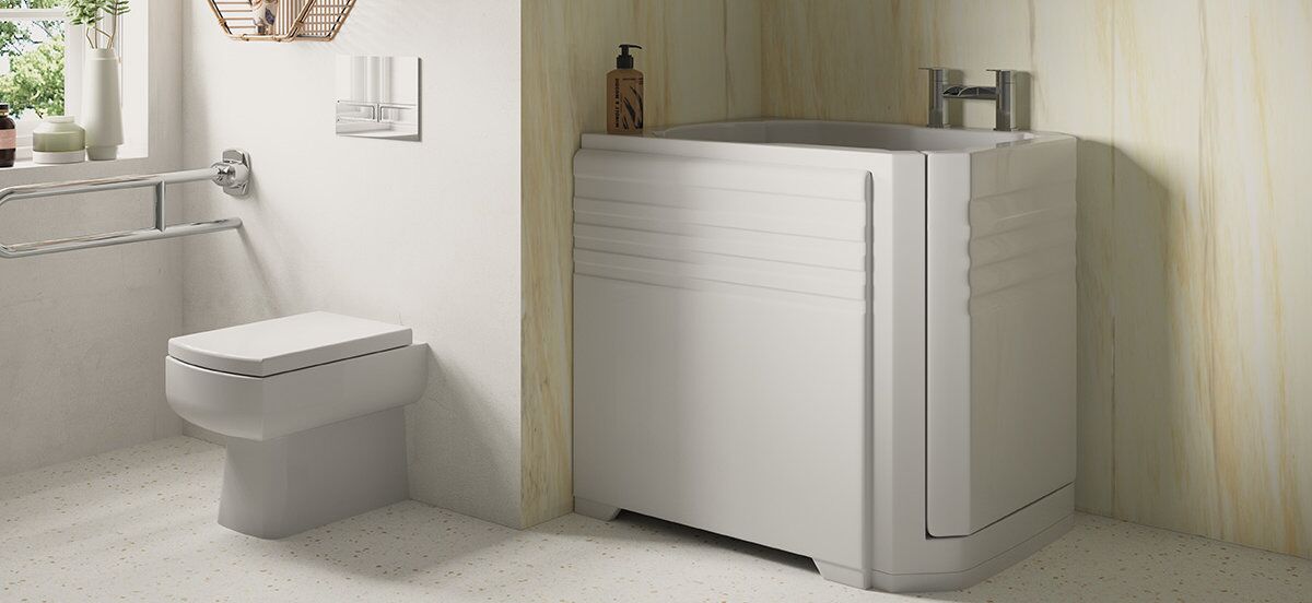 Modern accessible bathroom with a wall-mounted toilet, metal handrail, and a walk-in bathtub with a door and grab bars. There is a bottle of soap on the bathtub ledge. Light-colored walls and floor.