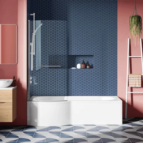 L-shaped bath with glass shower screen against blue hexagonal tiles and pink walls