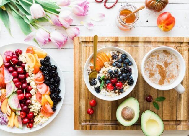 Beautiful table with fresh fruits, cereals, proteins, avocado and honney
