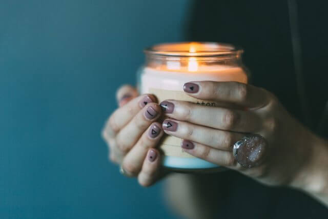 Large ambience candle held with two hands