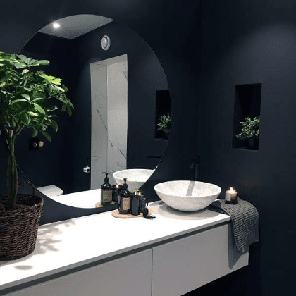 Interior design of contemporary toilet room with round mirror lamp small  black sink white walls with beige small square tiles Stock Photo - Alamy