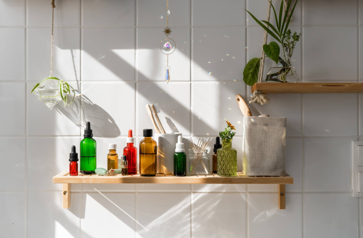 Wooden shelves with cosmetics and shadows on the tiled wall.