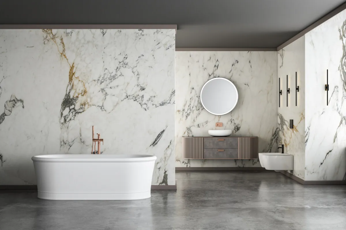 Modern luxury bathroom with white marble walls, freestanding bathtub, concrete floor, and indoor plants.